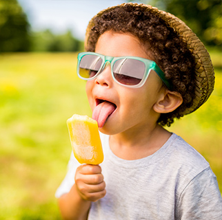 Two year old boy outside, enjoying ice cream.